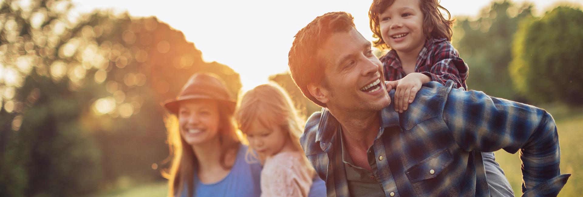 Happy family outdoors, smiles and play at sunset.